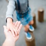 A Kid holding her fathers hand